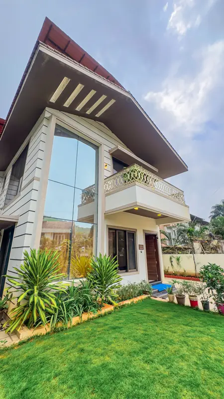 Villa facade with lawn and tall glass window